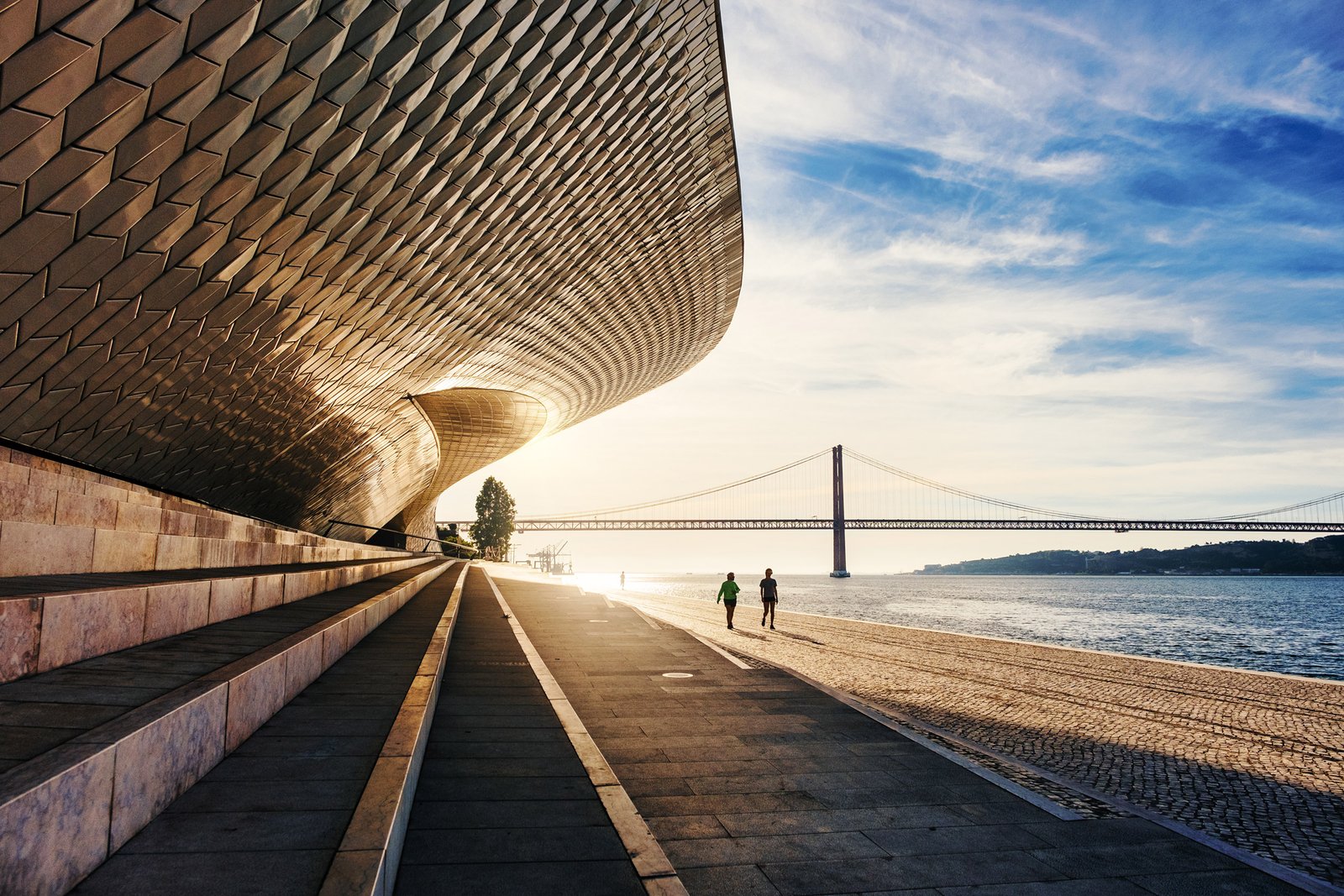 MAAT waterfront promenade with Ponte 25 de Abril over the rio tejo in Lisbon, Portugal
