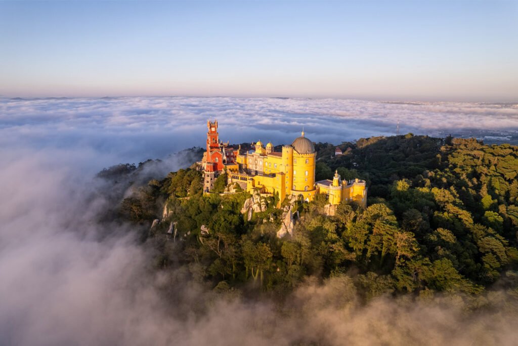 Palácio da Pena in Sintra rising above the clouds and forested hills, Portugal