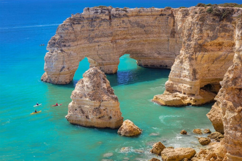 A wonderful view of the golden limestone cliffs and the famous Elephant Arch at Praia da Marinha, featuring crystal-clear turquoise waters in Lagoa, Algarve