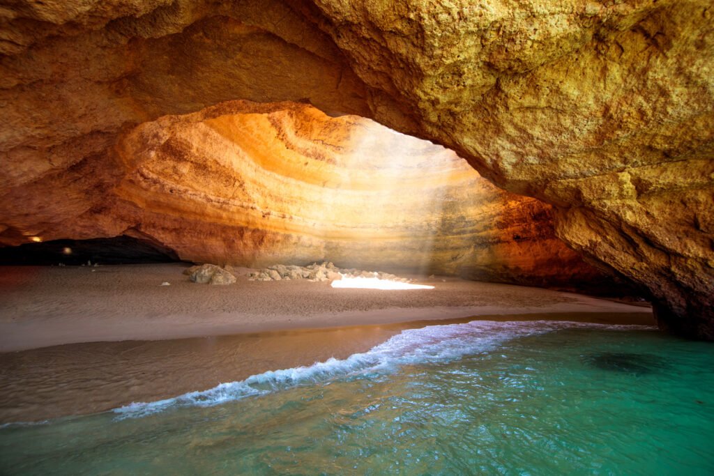Sea cave with golden cliffs and turquoise water on the Algarve coast, Portugal