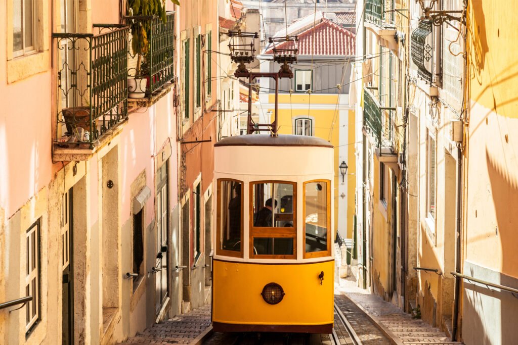 Yellow tram climbing a steep street in Lisbon, Portugal