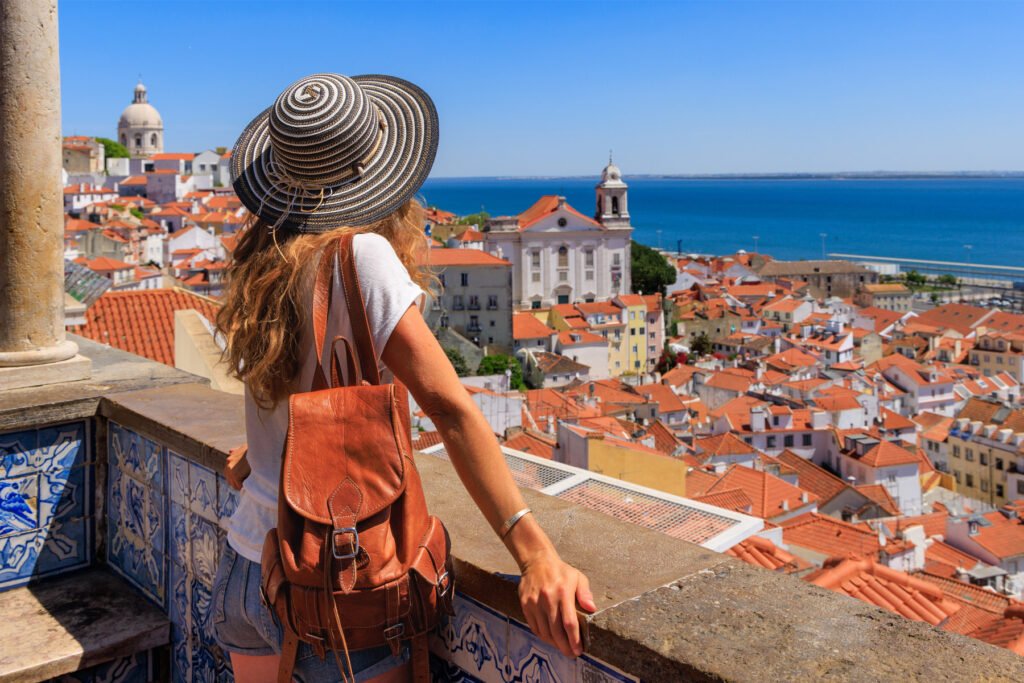 What to do in Portugal (2026): traveler overlooking Lisbon’s historic rooftops and the Atlantic