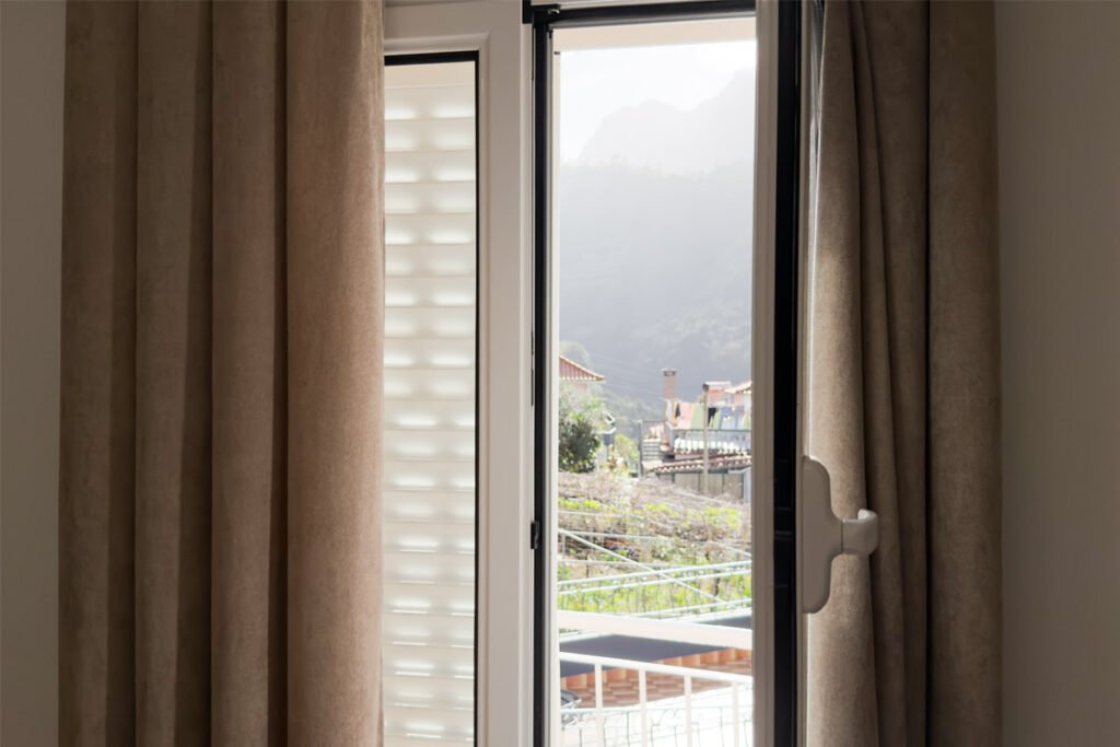 A relaxation lounge with large windows facing green mountains in a country house for vacations in Madeira.