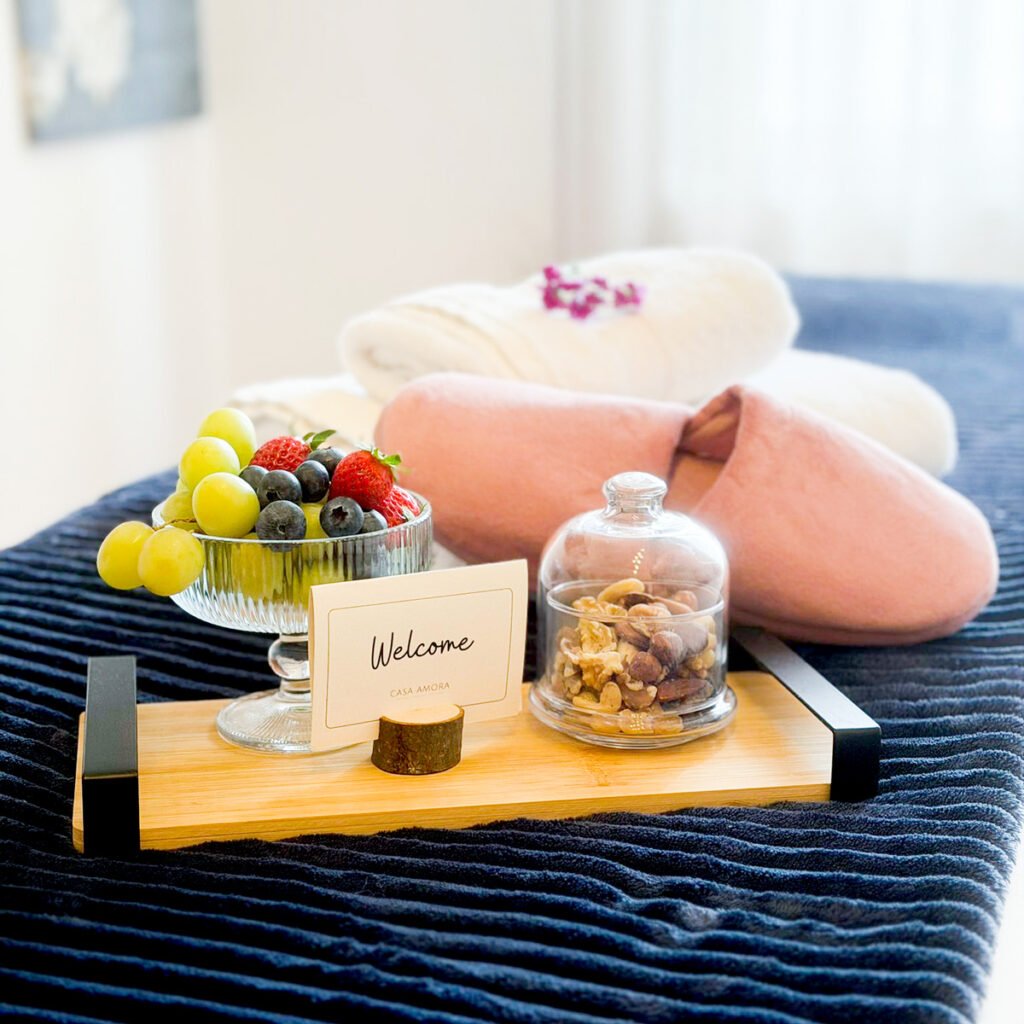 A high-end welcome tray inside an ocean view home in Caniço Madeira featuring fresh strawberries grapes blueberries and nuts next to a digital host tablet