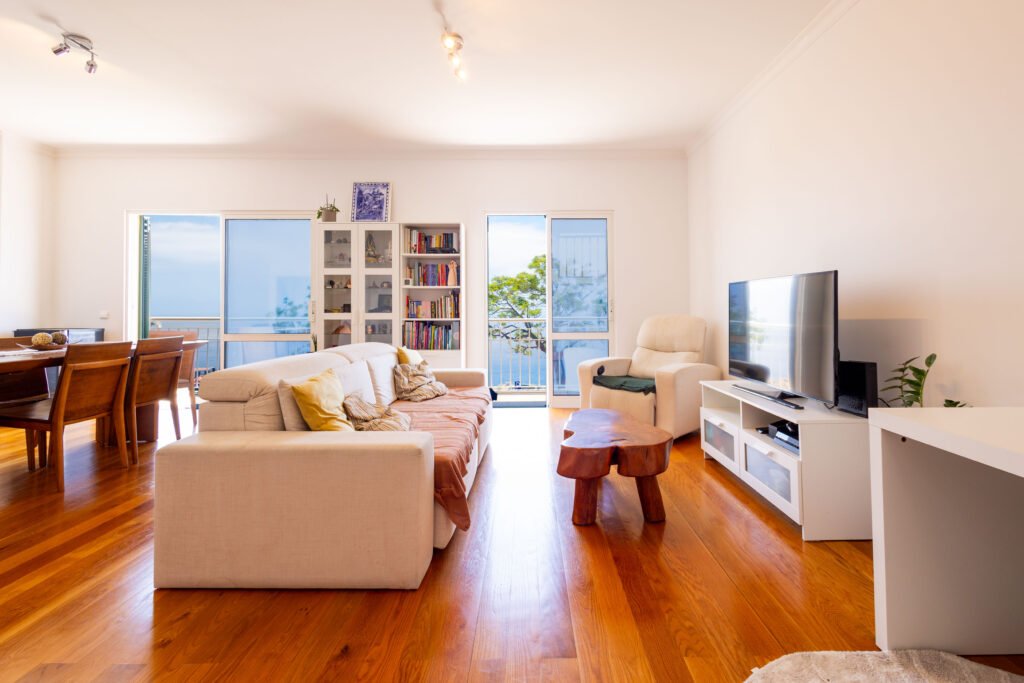 Spacious open plan living room with wooden floors in T3 duplex apartment for sale in Funchal Madeira