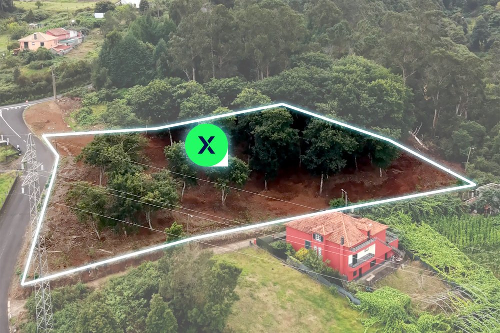 Drone perspective showing plot boundaries of land for sale in Santana next to rural houses